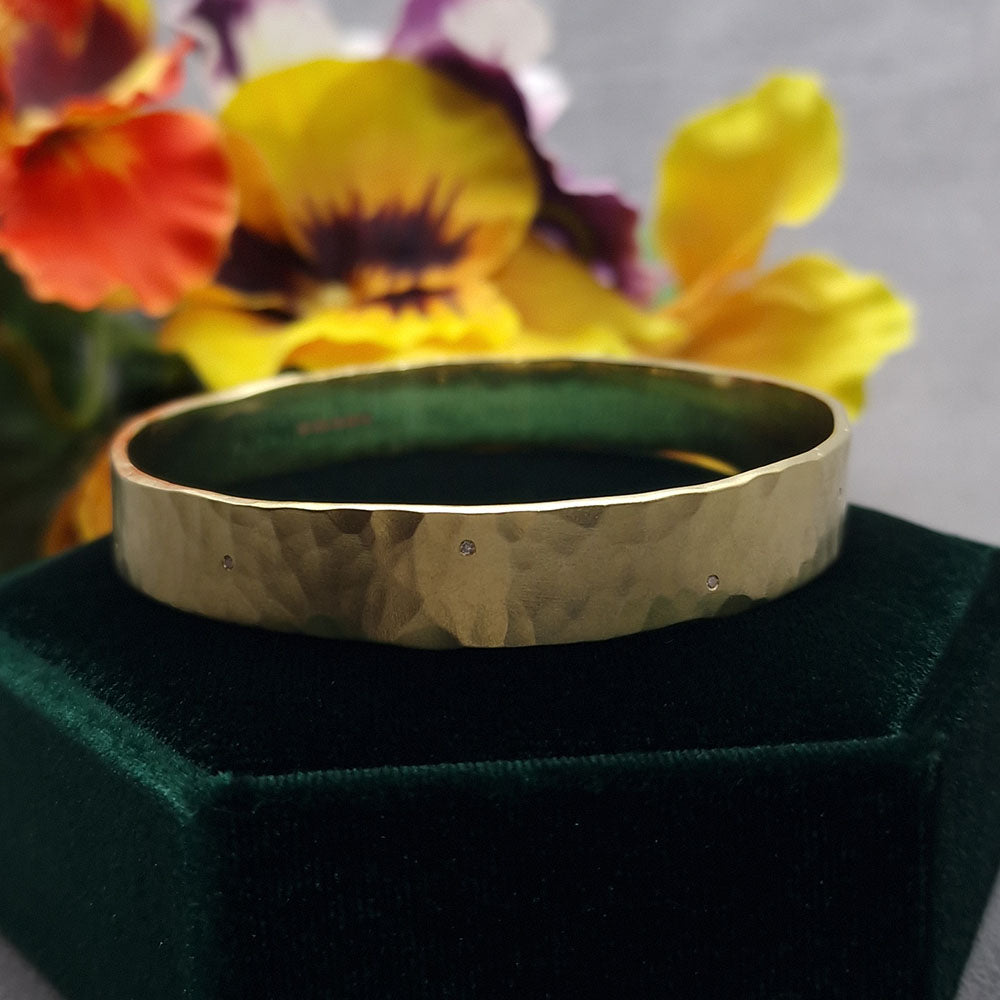 9ct Yellow Gold Bangle, with Twelve Diamonds Flush Set at Equidistance around the Band with a Hammered, Satin Finish. Bespoke design made using our customers remodelled Gold at Golden Snowdrop the jewellers in Shaftesbury, near Salisbury.  