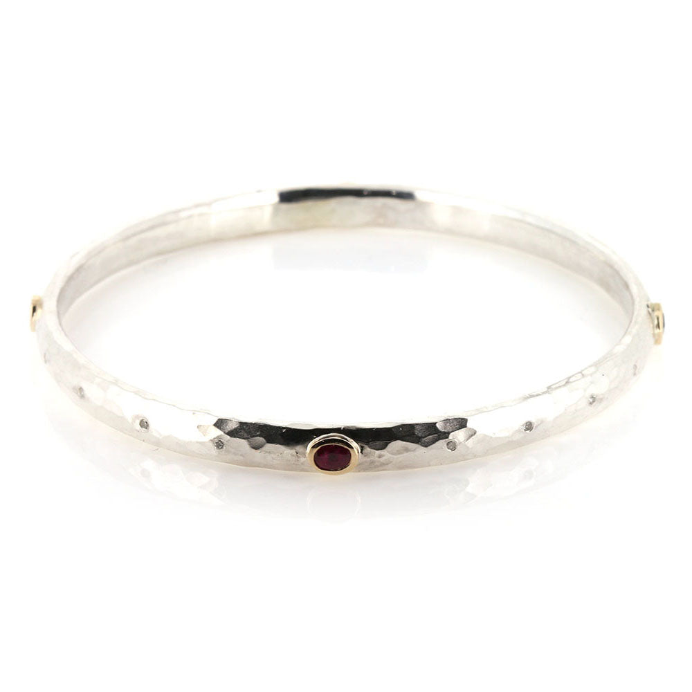 The final peice, a Ruby, Sapphire and Diamond Hammered Bangle in Sterling Silver with 9ct Yellow Gold Settings. 
Remodelled using our customers original gold and stones, at Golden Snowdrop the jewellers in Shaftesbury, near Queen Camel. 