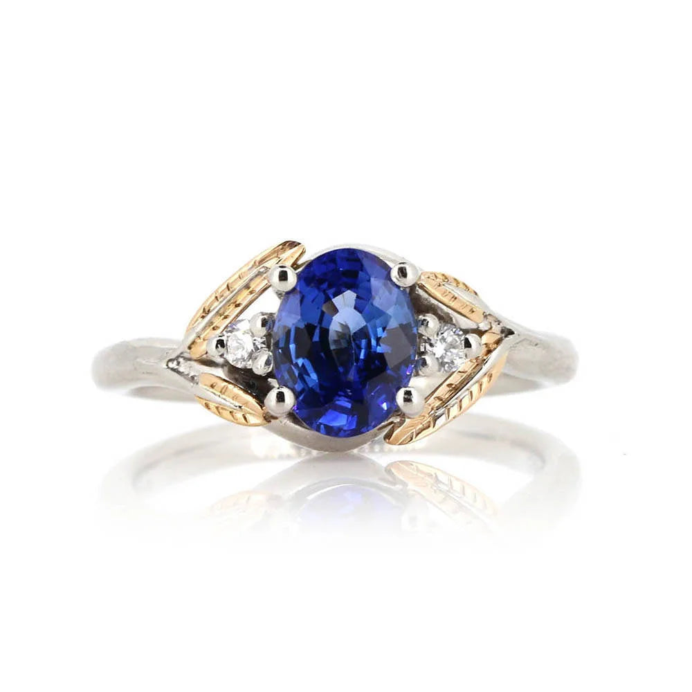 Wedding ring with a blue sapphire gemstone and gold accents on a white background