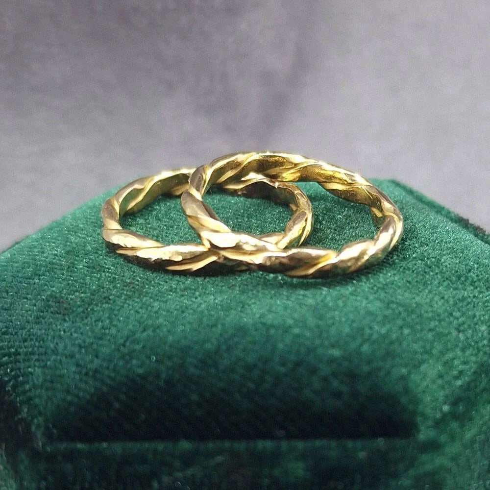 A pair of bespoke twisted yellow gold wedding rings, handcrafted with an organic spiral design, at Golden Snowdrop the jewellers in Shaftesbury, near Warminster. 