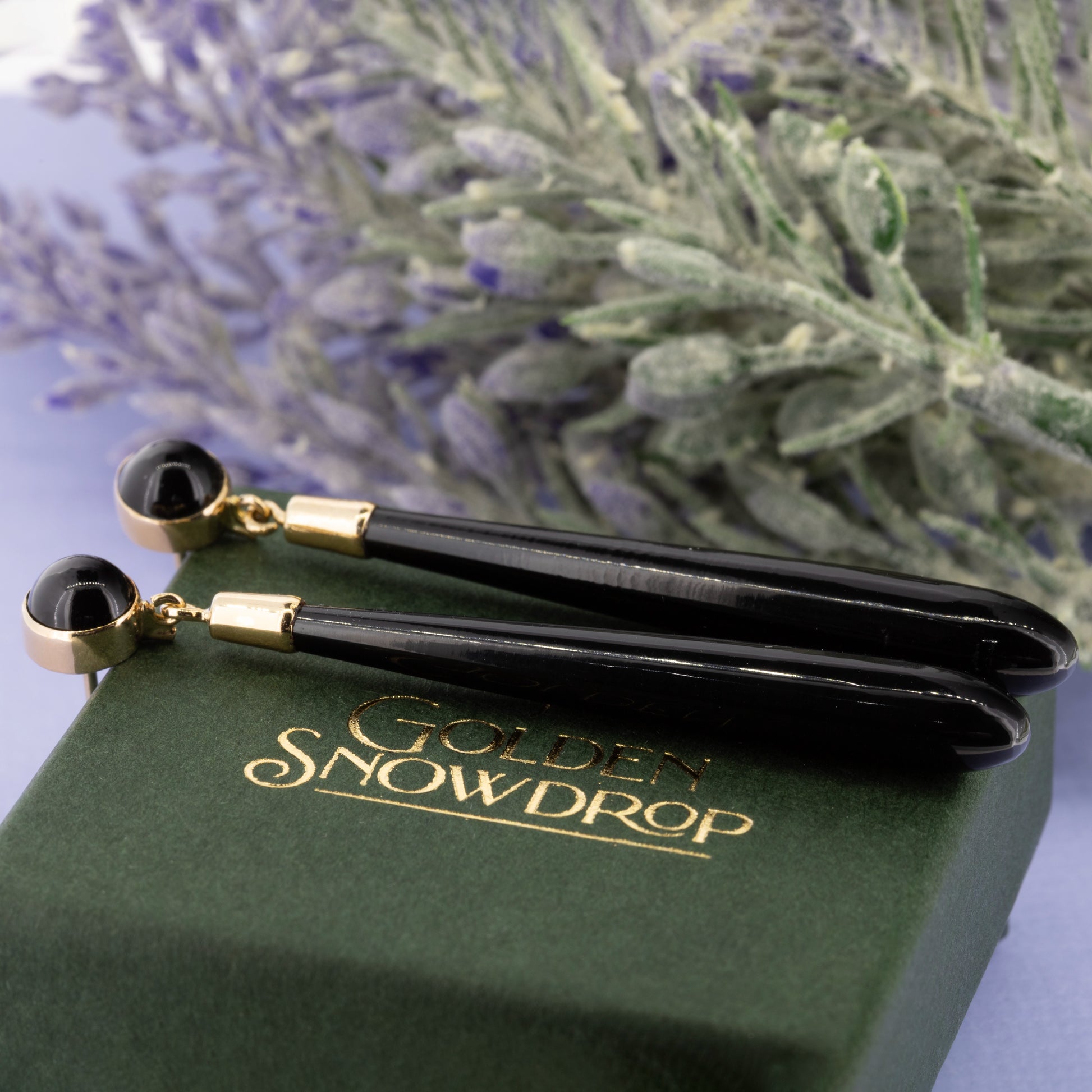 Close up of black onyx drop earring with polished gold cap and fitting | Golden Snowdrop